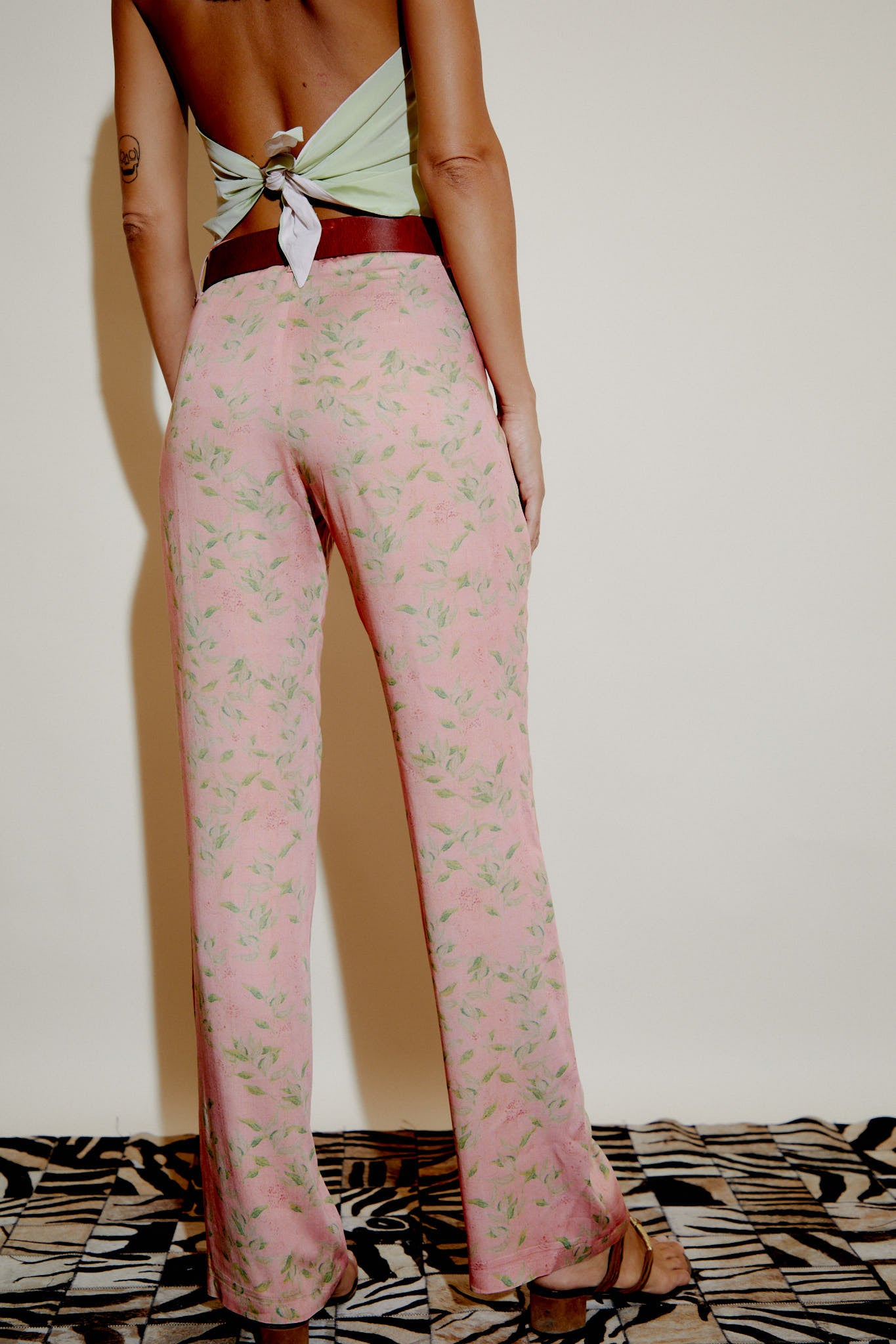 Pink leaf-print trousers with straight fit, front pleats, and ankle-length hem