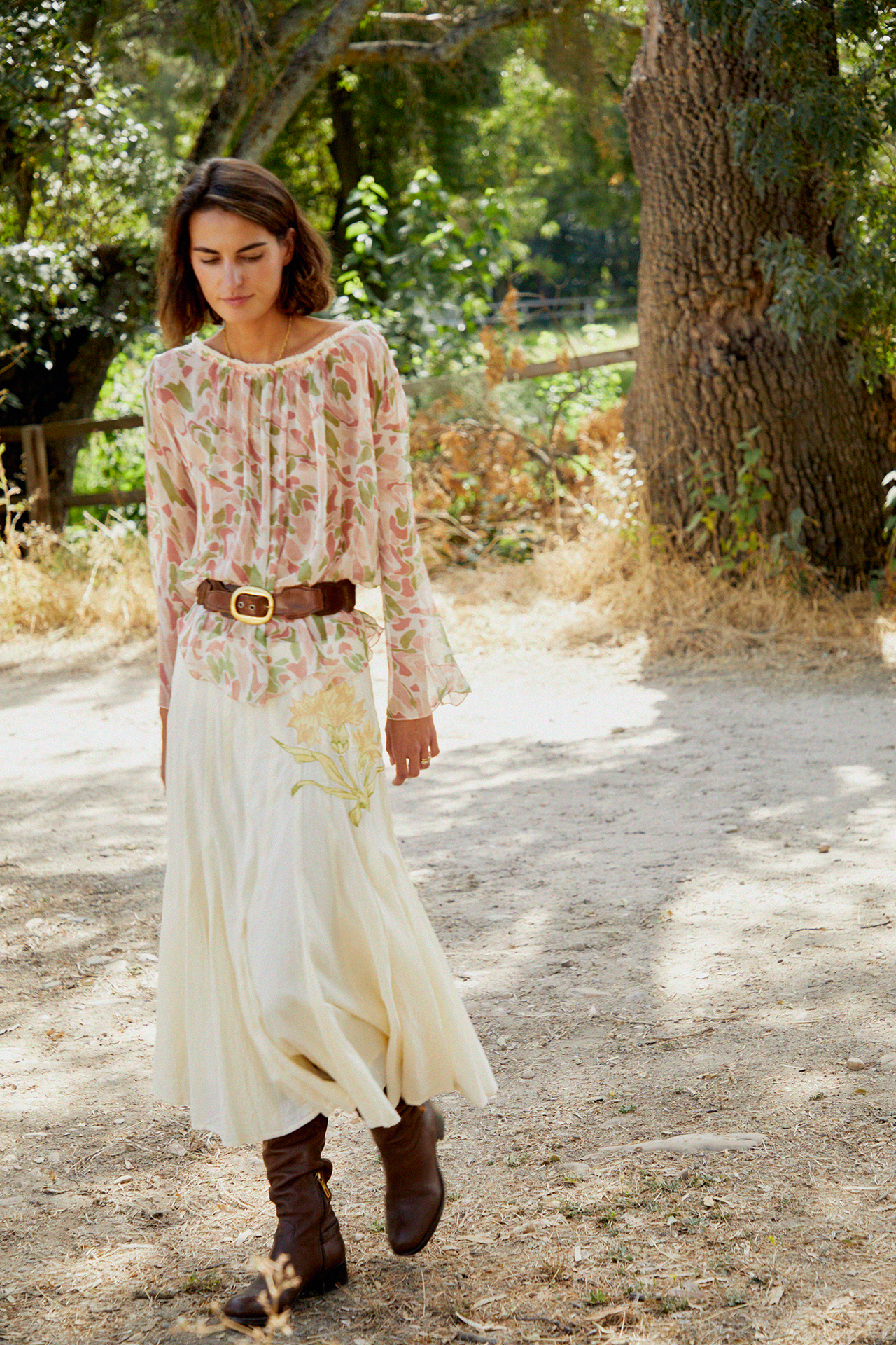 Cream tiered midi skirt with layered pleats and floral embroidery at the front