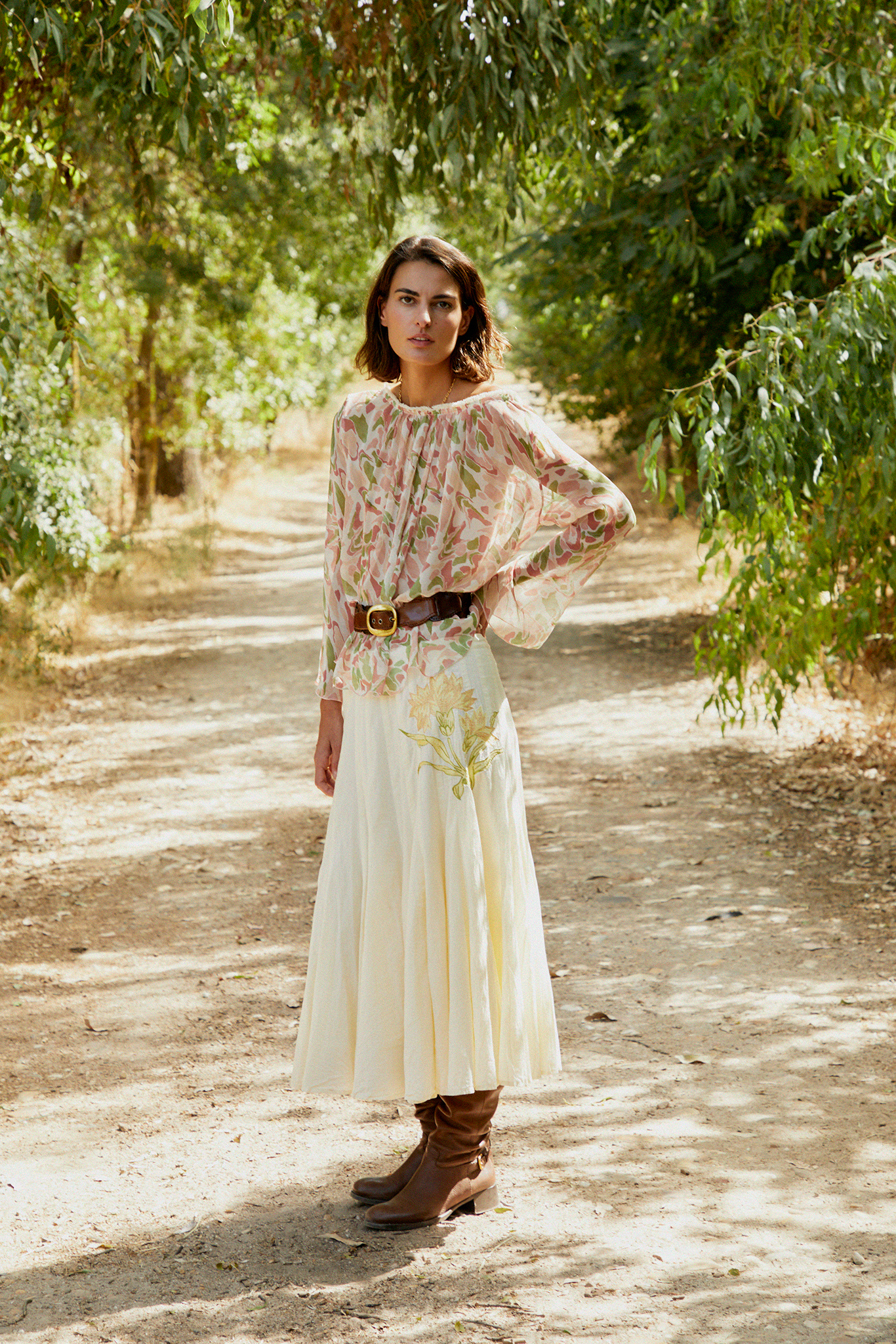 Cream tiered midi skirt with subtle floral embroidery and pleated tiers