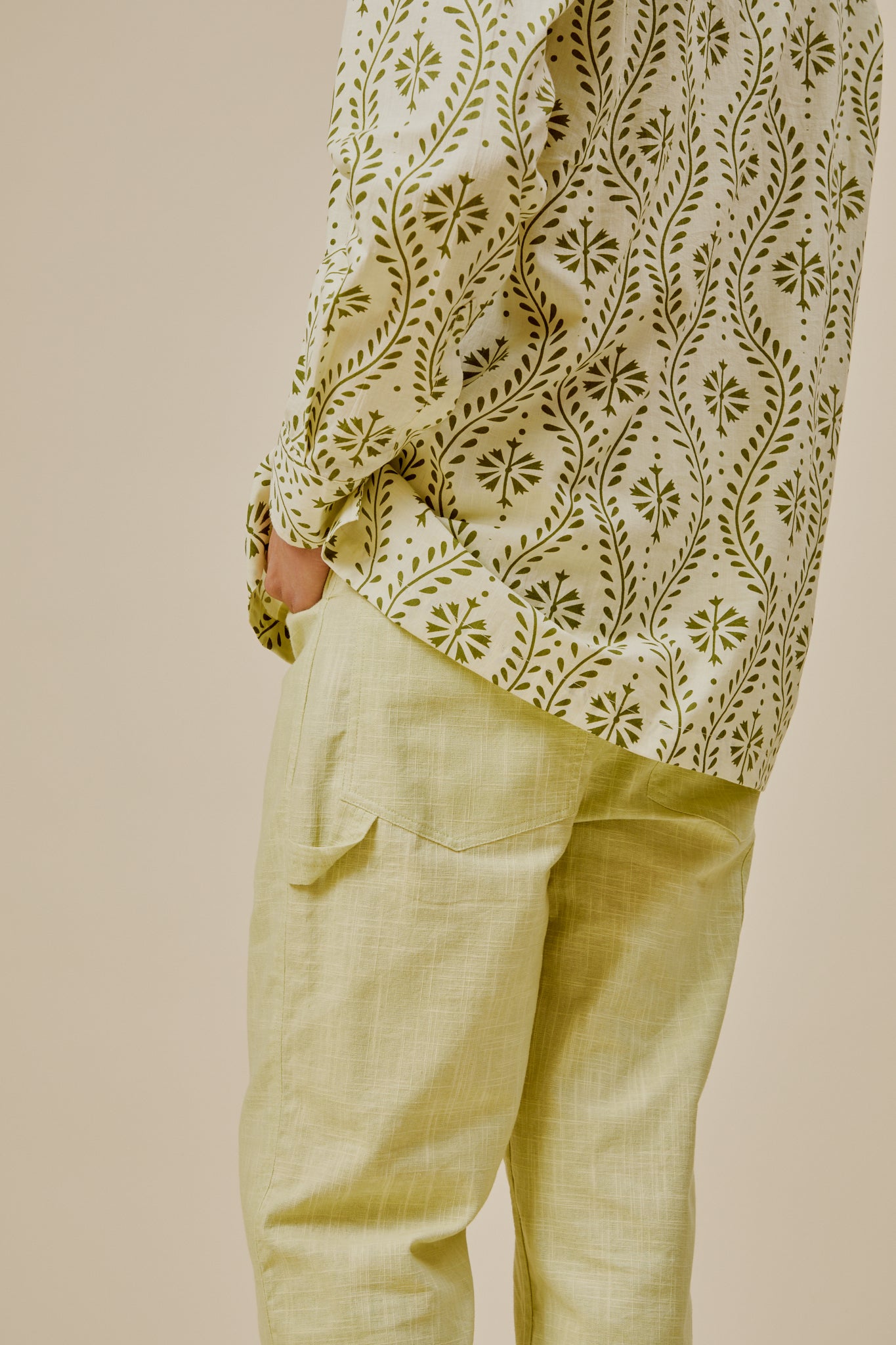 Side hem and pocket detail on green leaf-and-flower print shirt