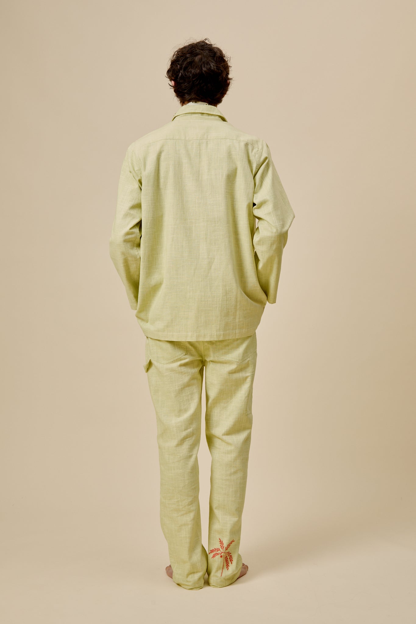 Light green jacket from the back with button placket and structured collar, no embroidery visible.