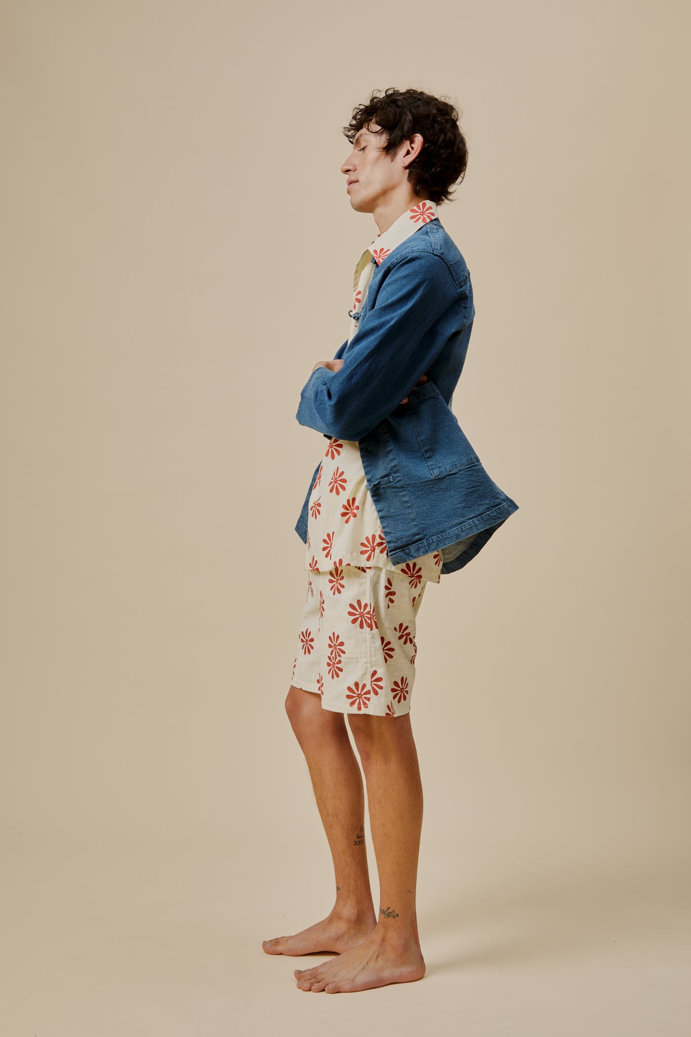 Floral bermuda shorts, white with red flower print, side view above-knee hem