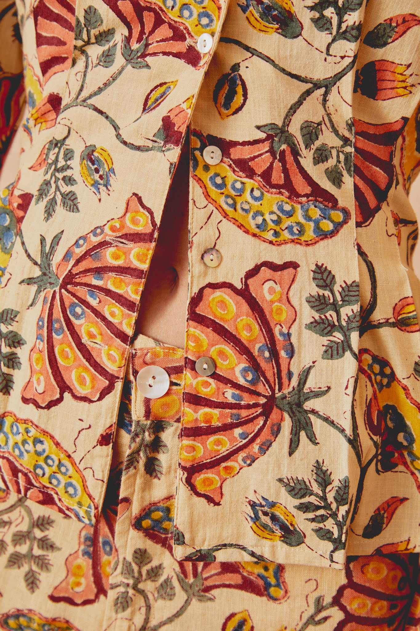 Beige long-sleeve shirt front placket with visible white buttons