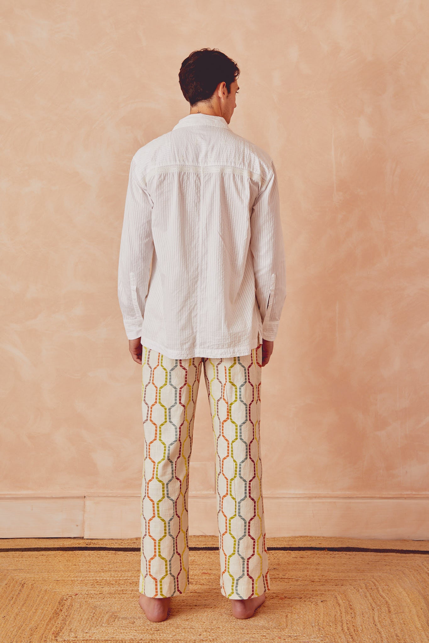 Tony trousers back view, off-white with multicolor linked pattern and drawstring waist.