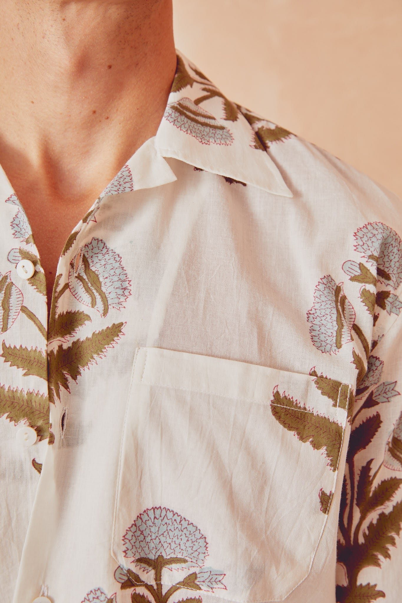 White button-up shirt collar close-up with botanical floral print and chest pocket