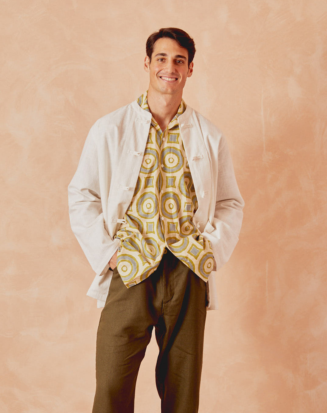 Cream kitchen overshirt worn open over shirt, button front and patch pocket