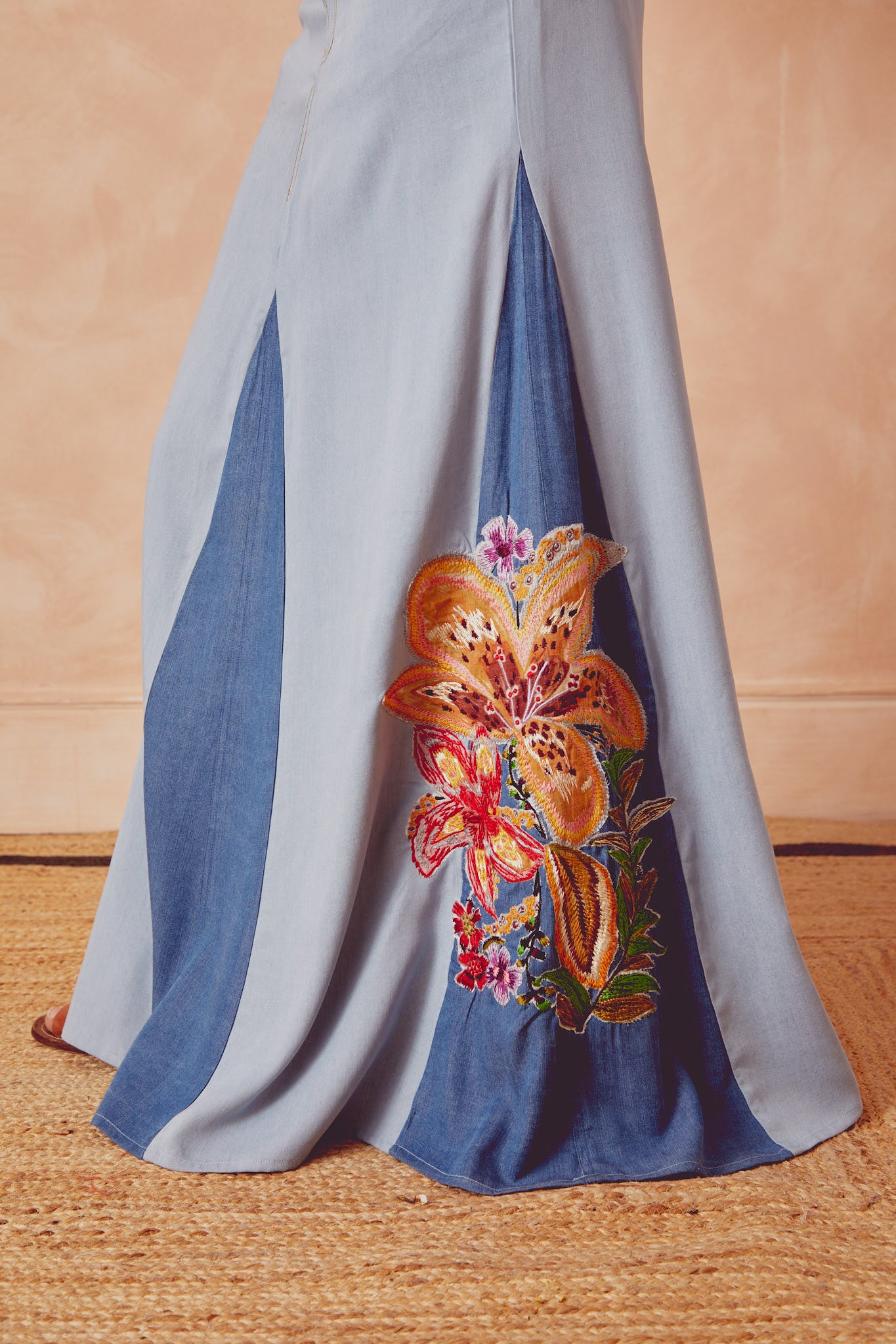 Light blue denim skirt with front slit and large multicolor butterfly floral appliqué