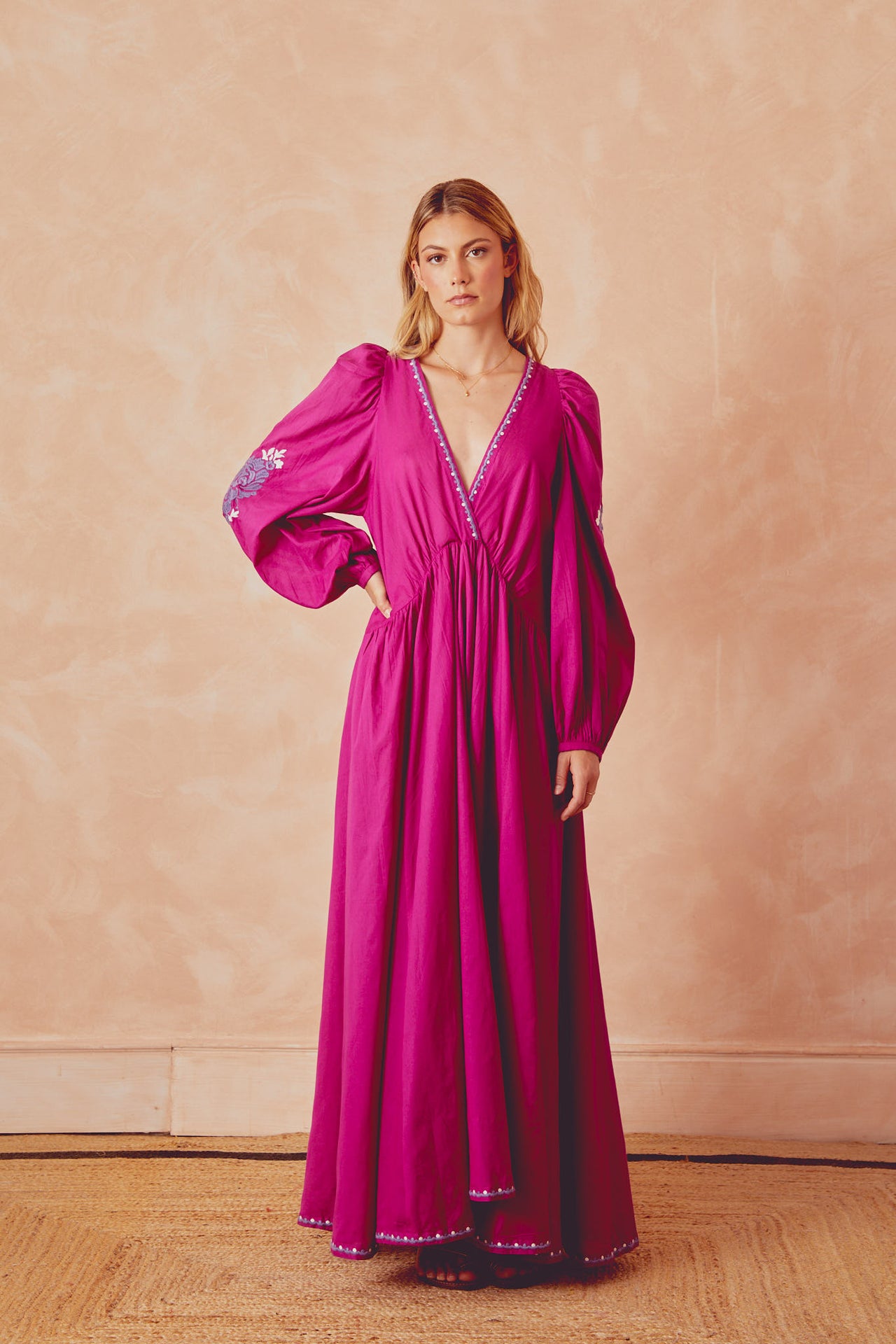 Magenta long dress with V-neck edging, puff sleeves, and embroidered border at hem