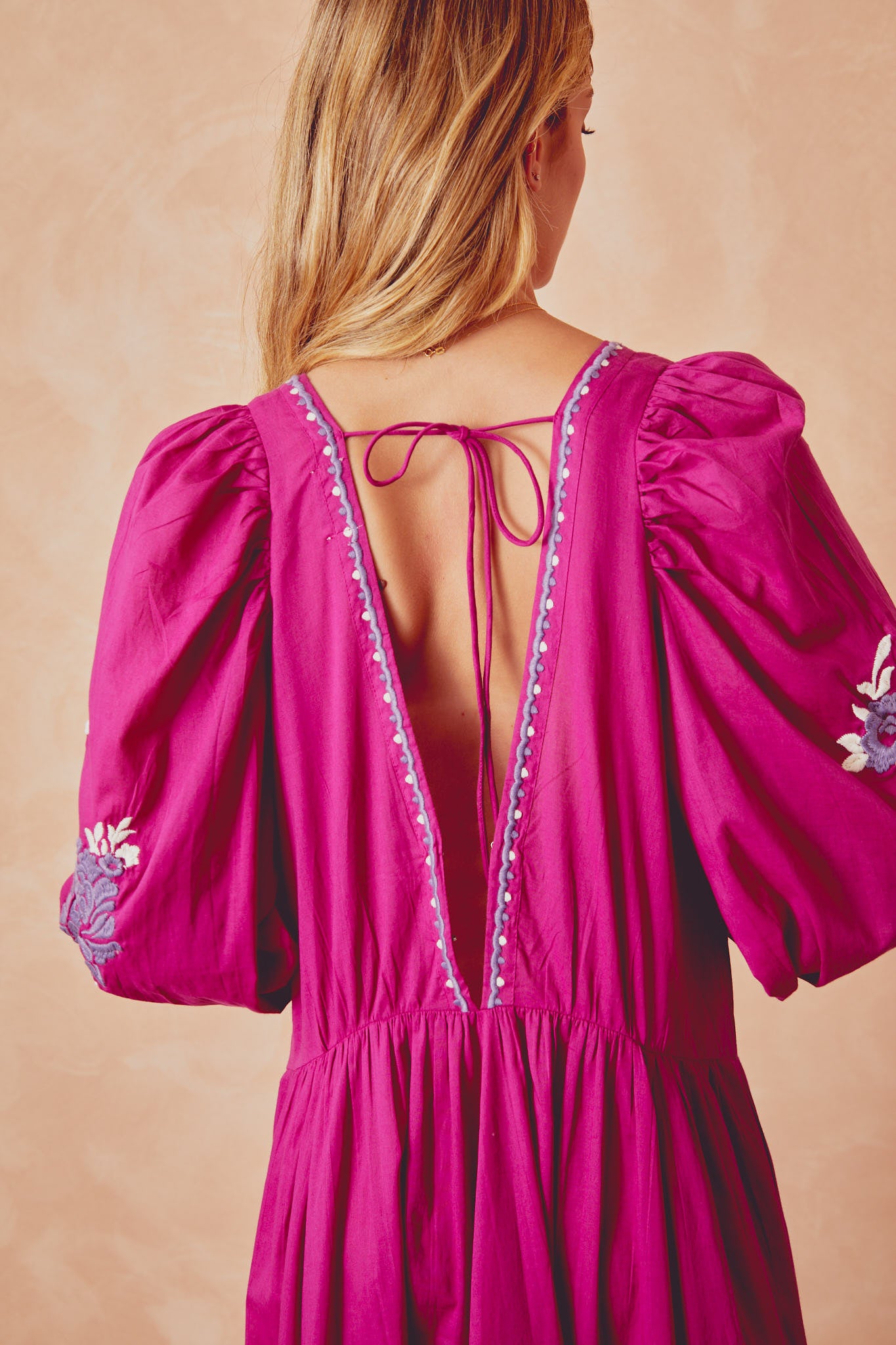 Back view of magenta Isla dress with lace trim and crisscross tie strap