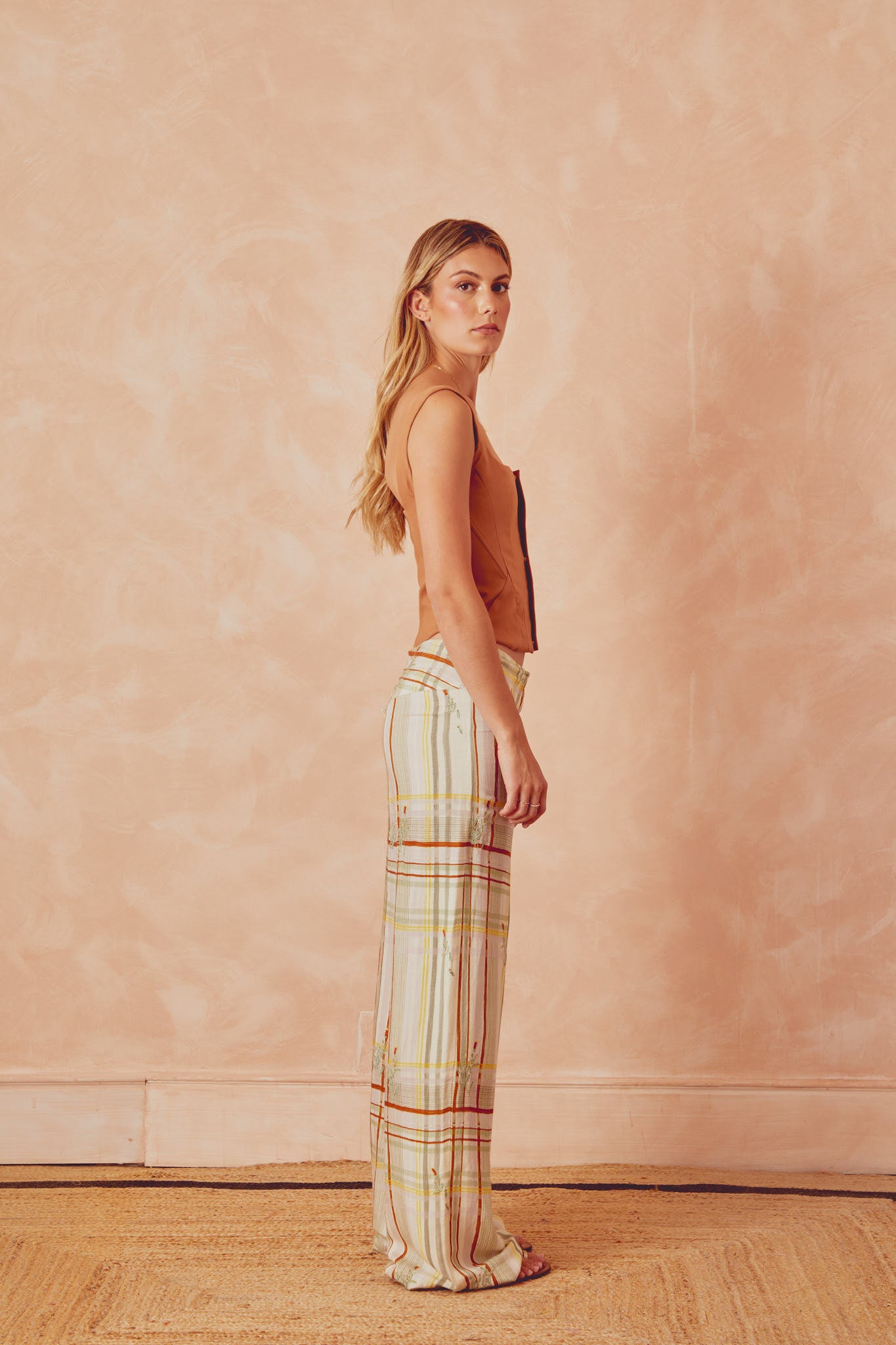 Plaid wide-leg trousers in light tones with vertical stripe lines, side view