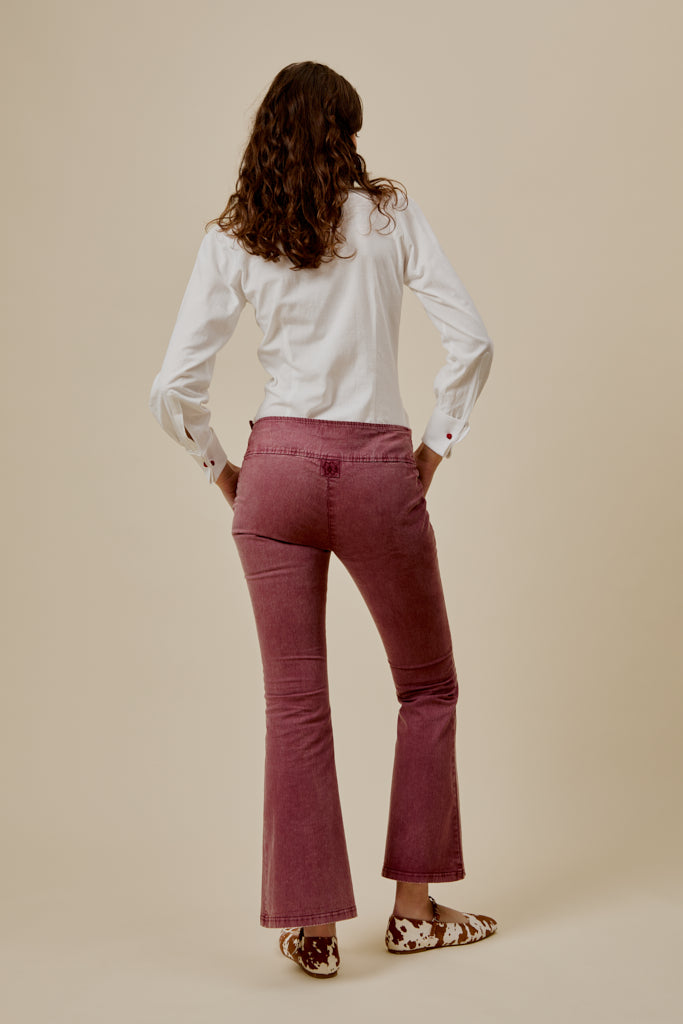 Burgundy flared trousers with studded belt and back pocket seam detail