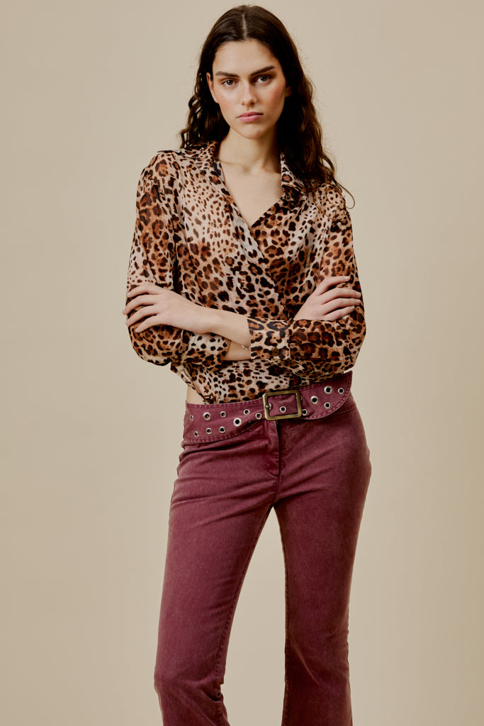 Burgundy flared jeans with studded belt and metal buckle at the waist