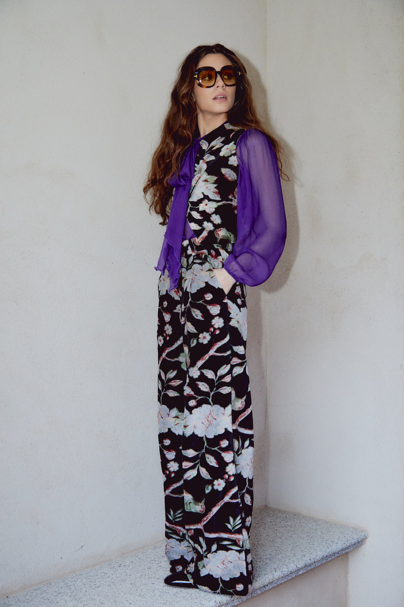 Black floral wide-leg trousers with large pink blooms and green foliage, side view