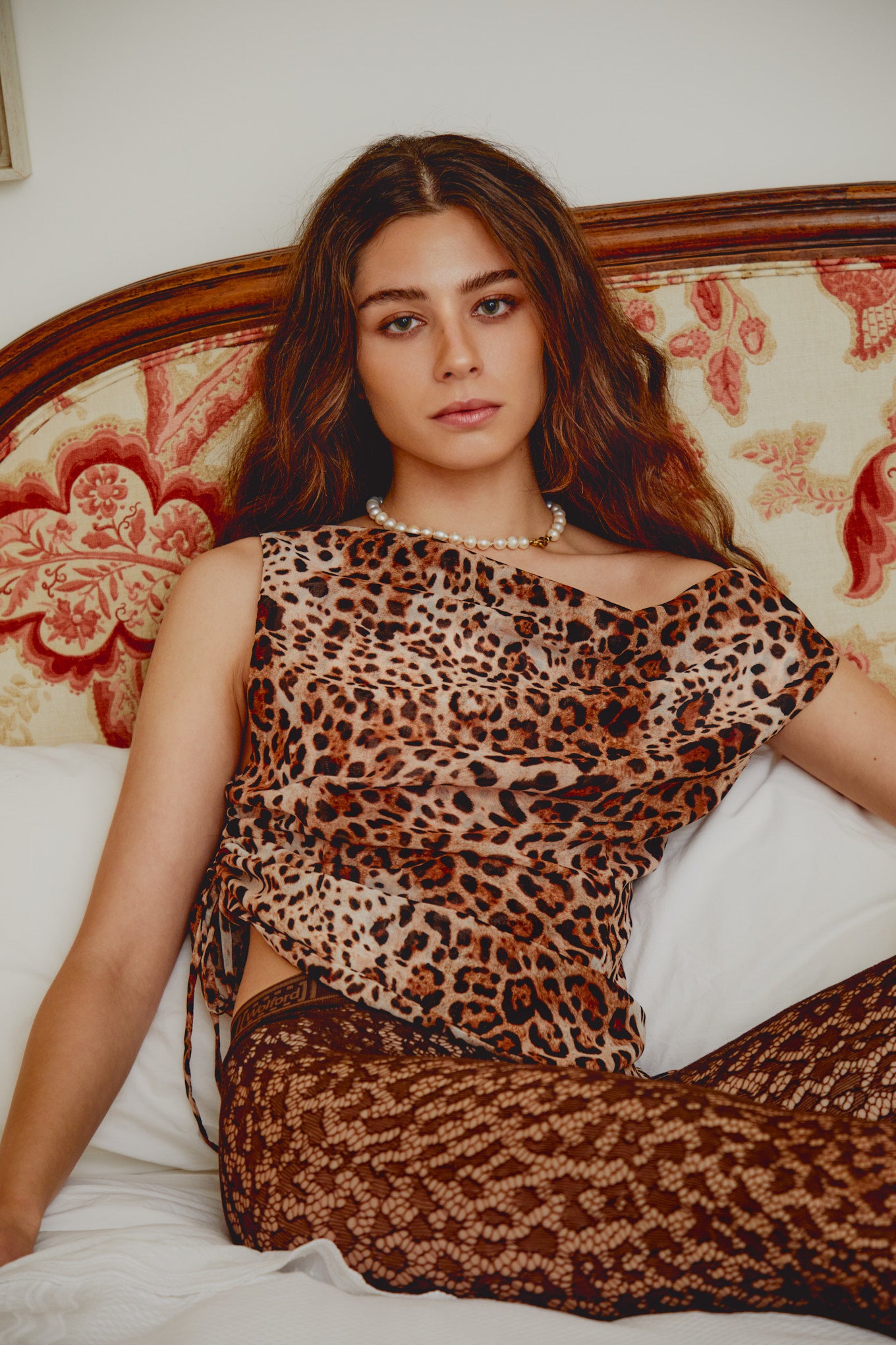 Leopard-print sleeveless top with off-shoulder neckline and layered drape.