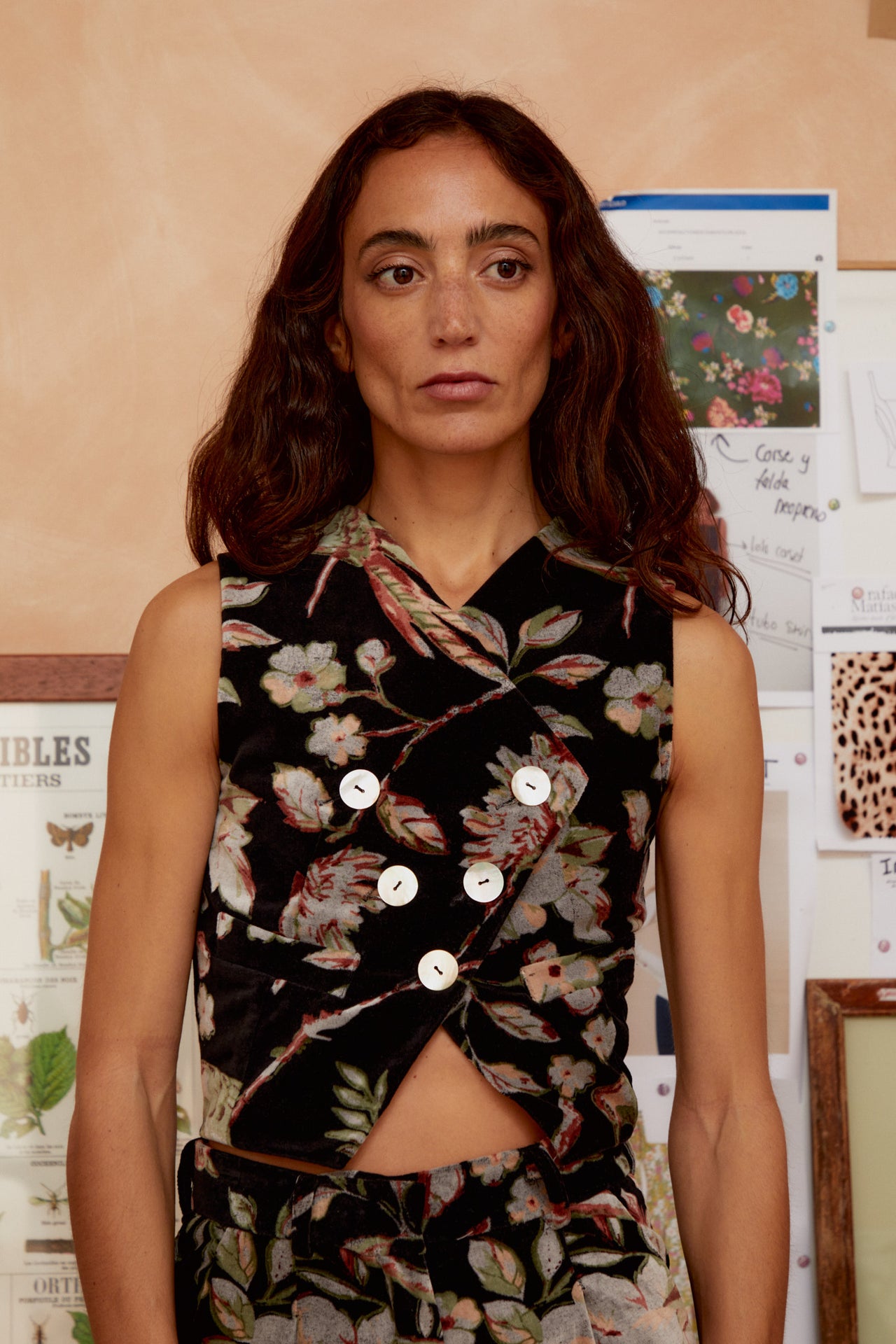 Black floral sleeveless vest with crossed V-neck and round front buttons