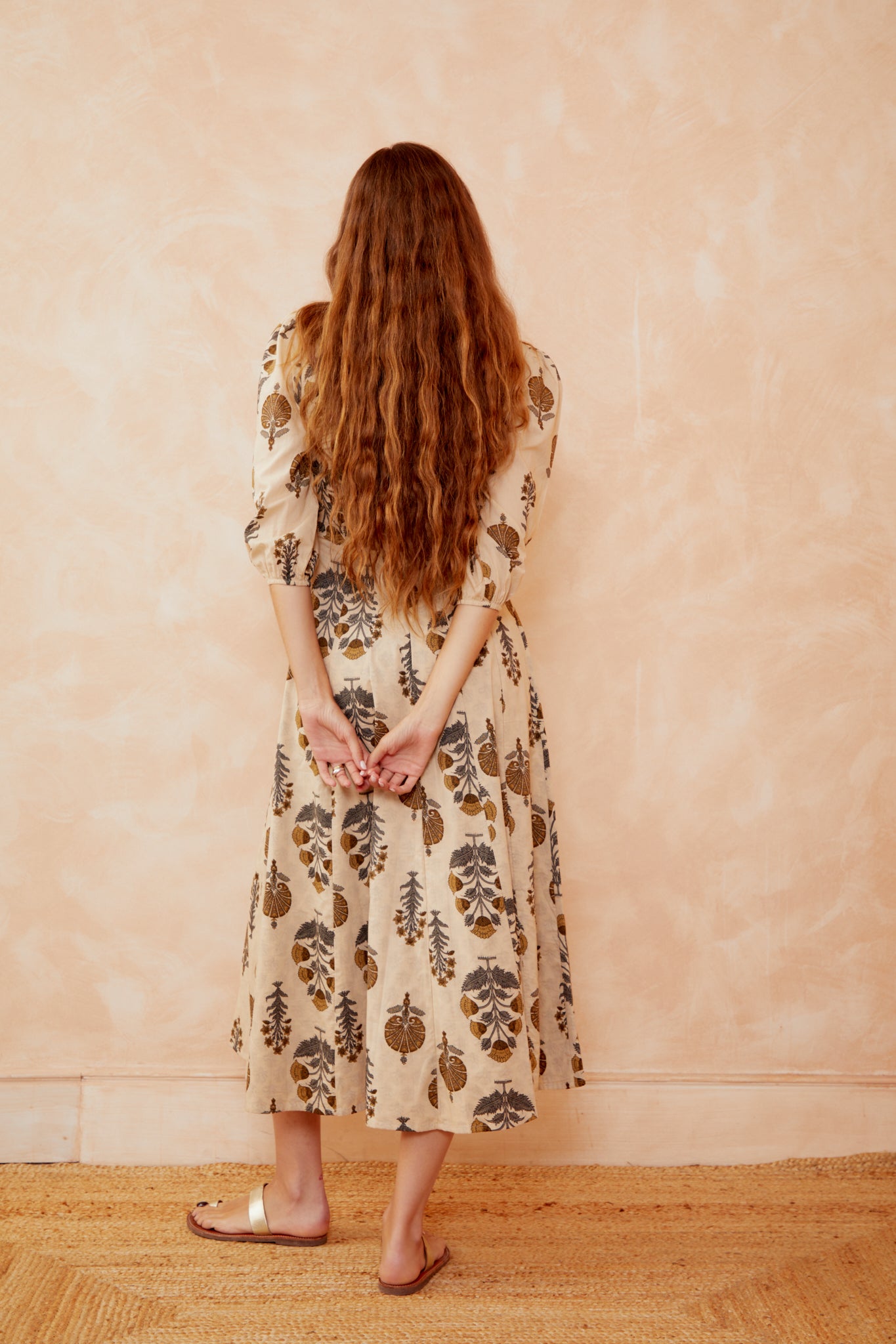 Cream botanical print dress, back view with puff sleeves and gathered waist