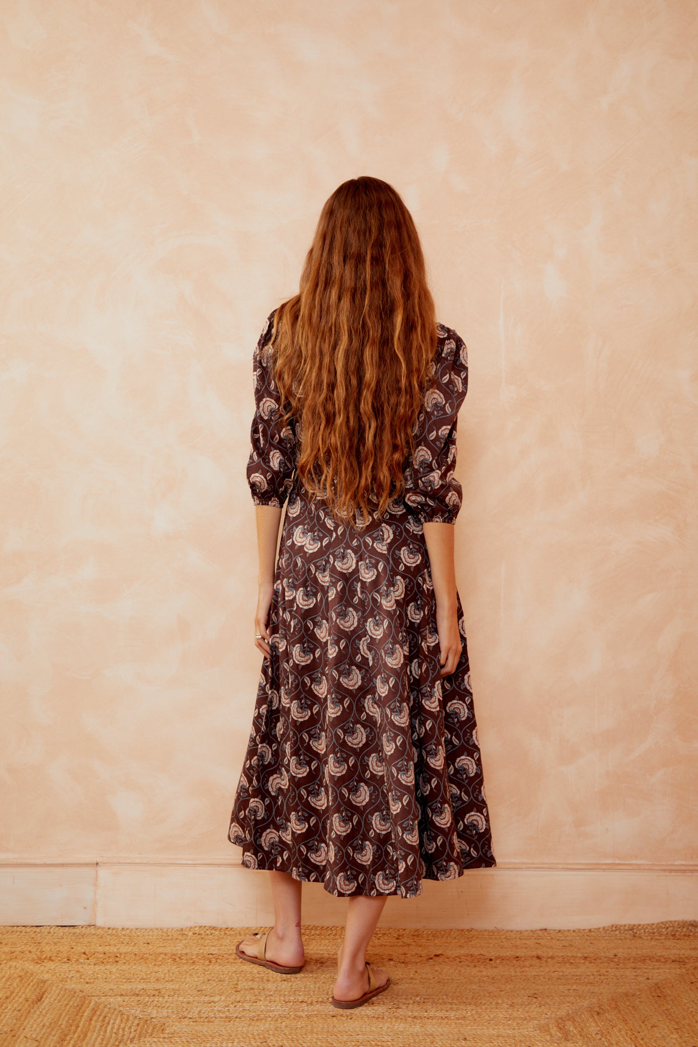 Back view of dark coffee paisley midi dress with square back and puff sleeves