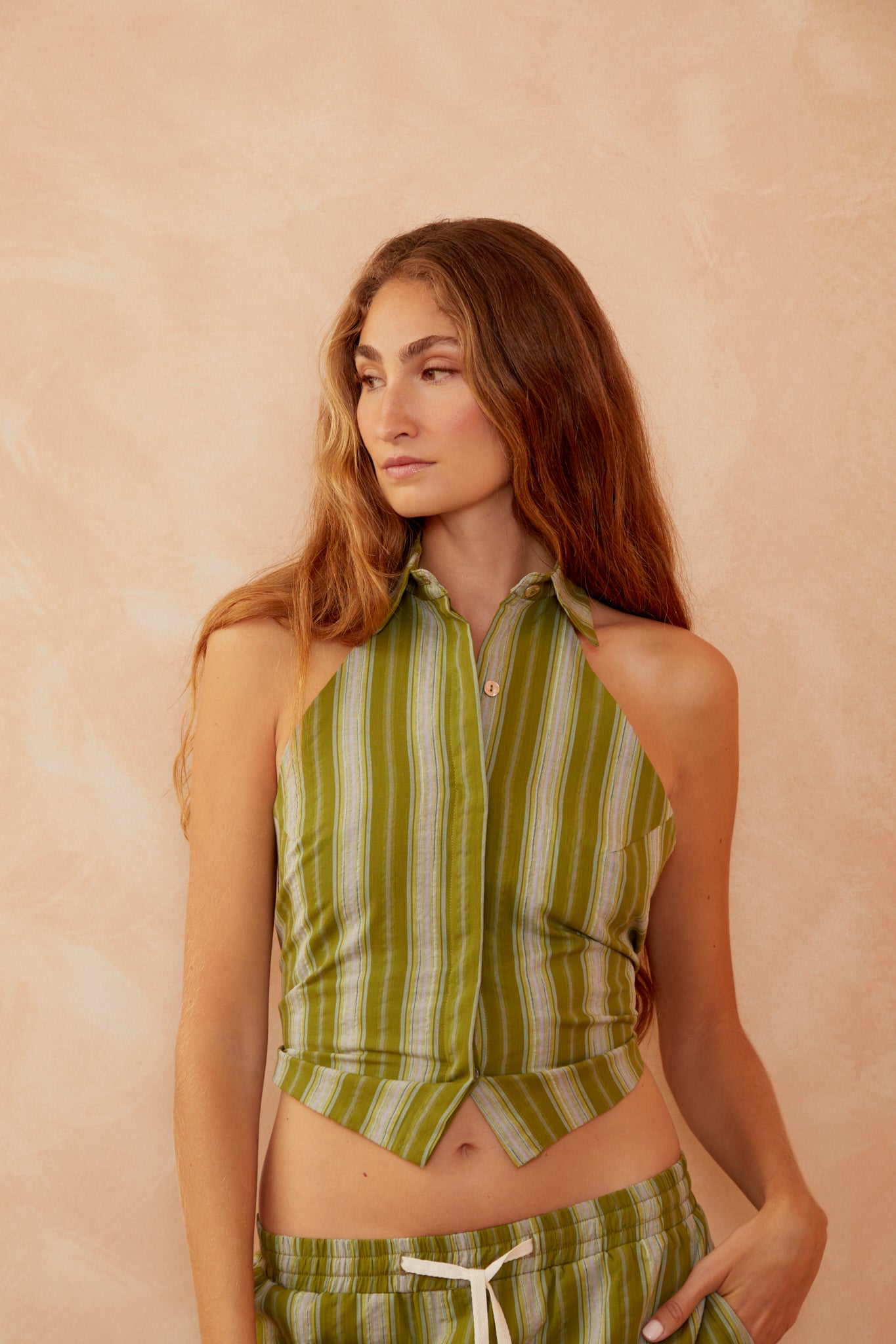 Green-striped sleeveless button-up top with pointed collar and chest pockets