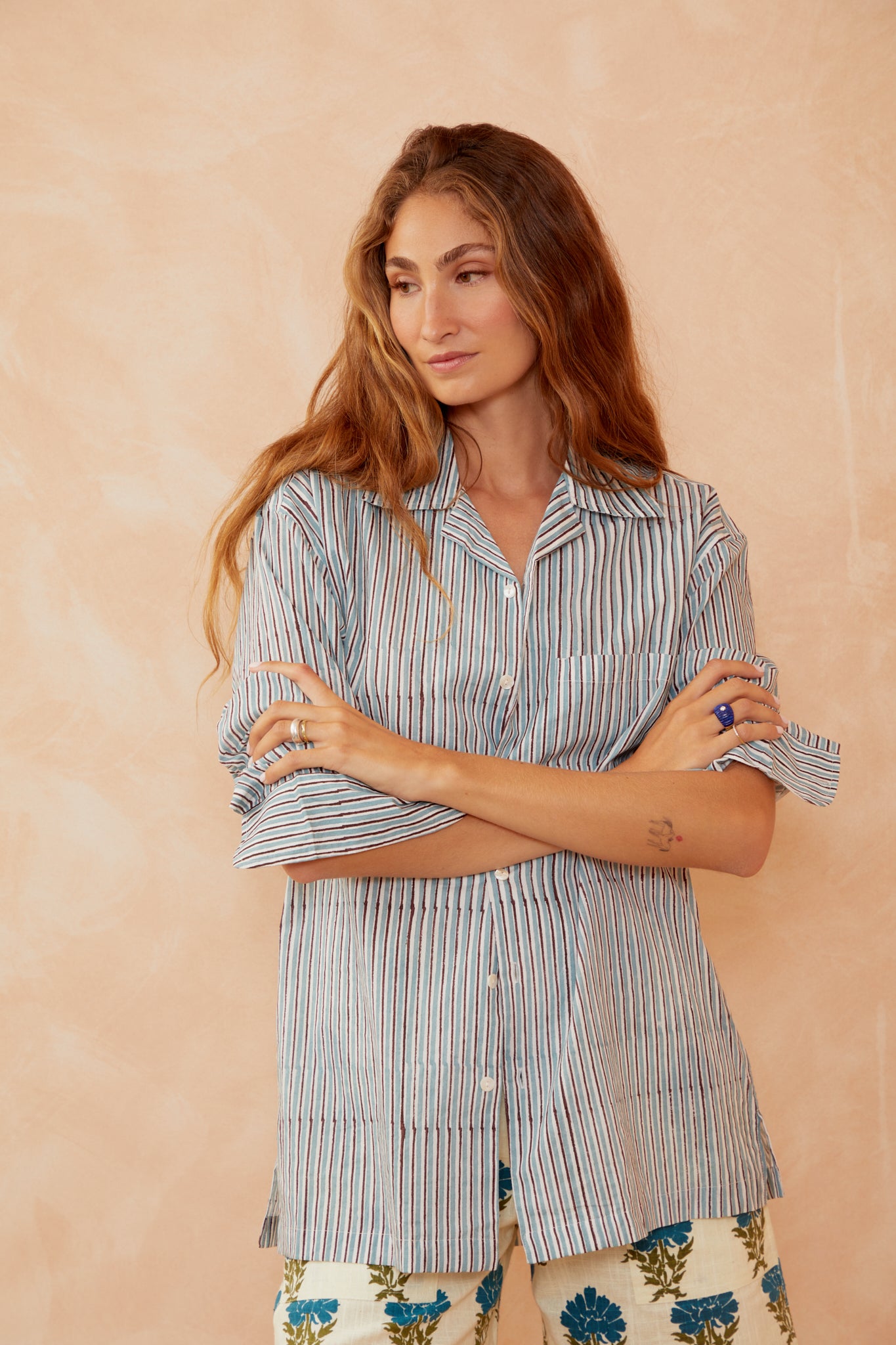Blue striped button-up shirt with open collar and long sleeves.