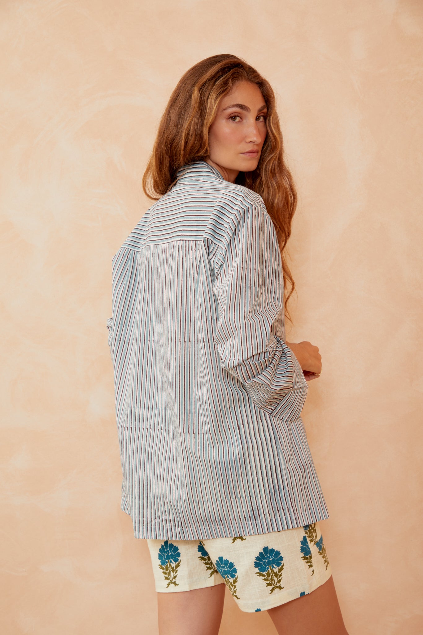 Blue striped button-up shirt with collar, long sleeves, side/back view.