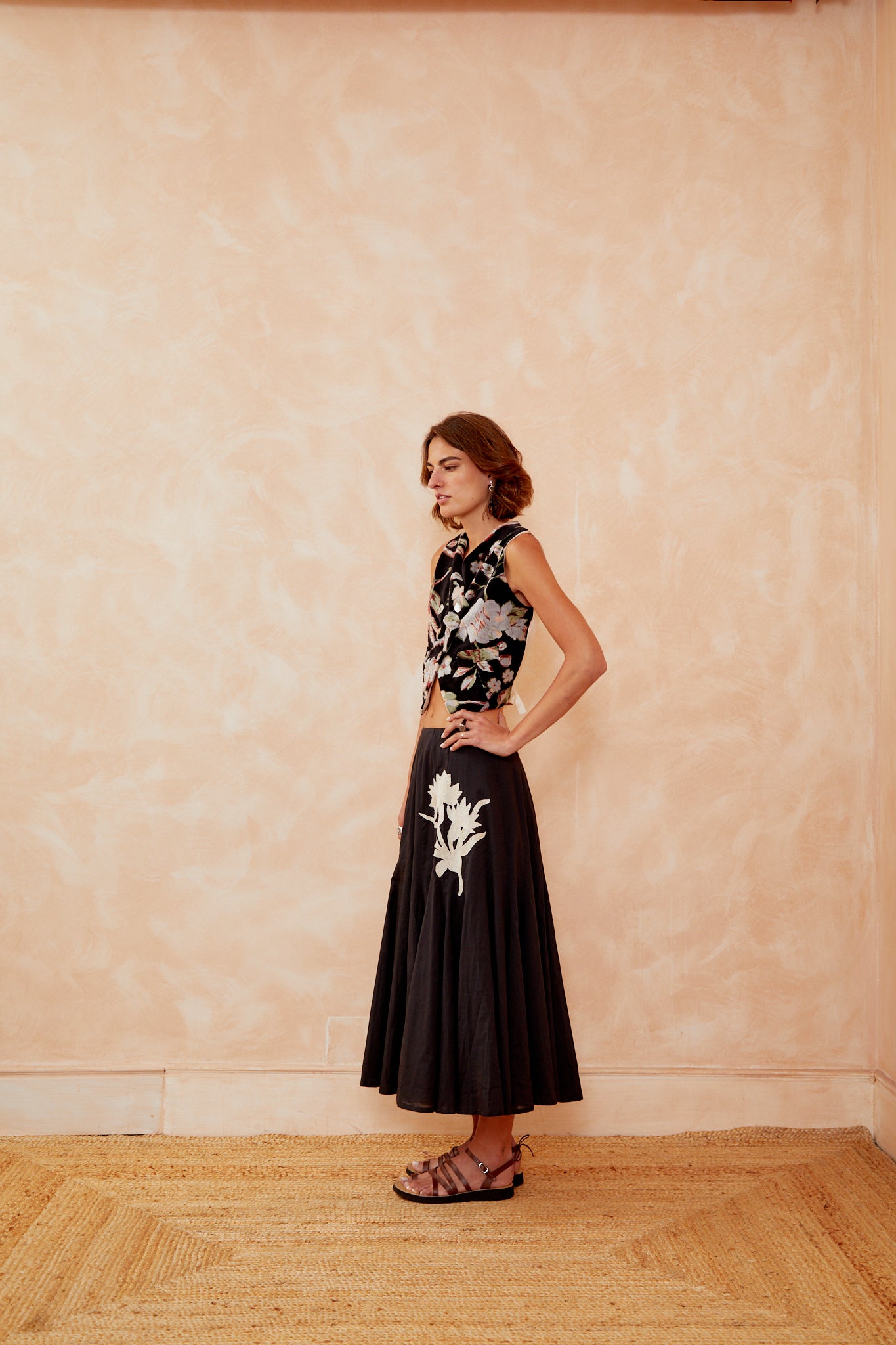 Black floral sleeveless vest with V-neck and buttoned crossed front