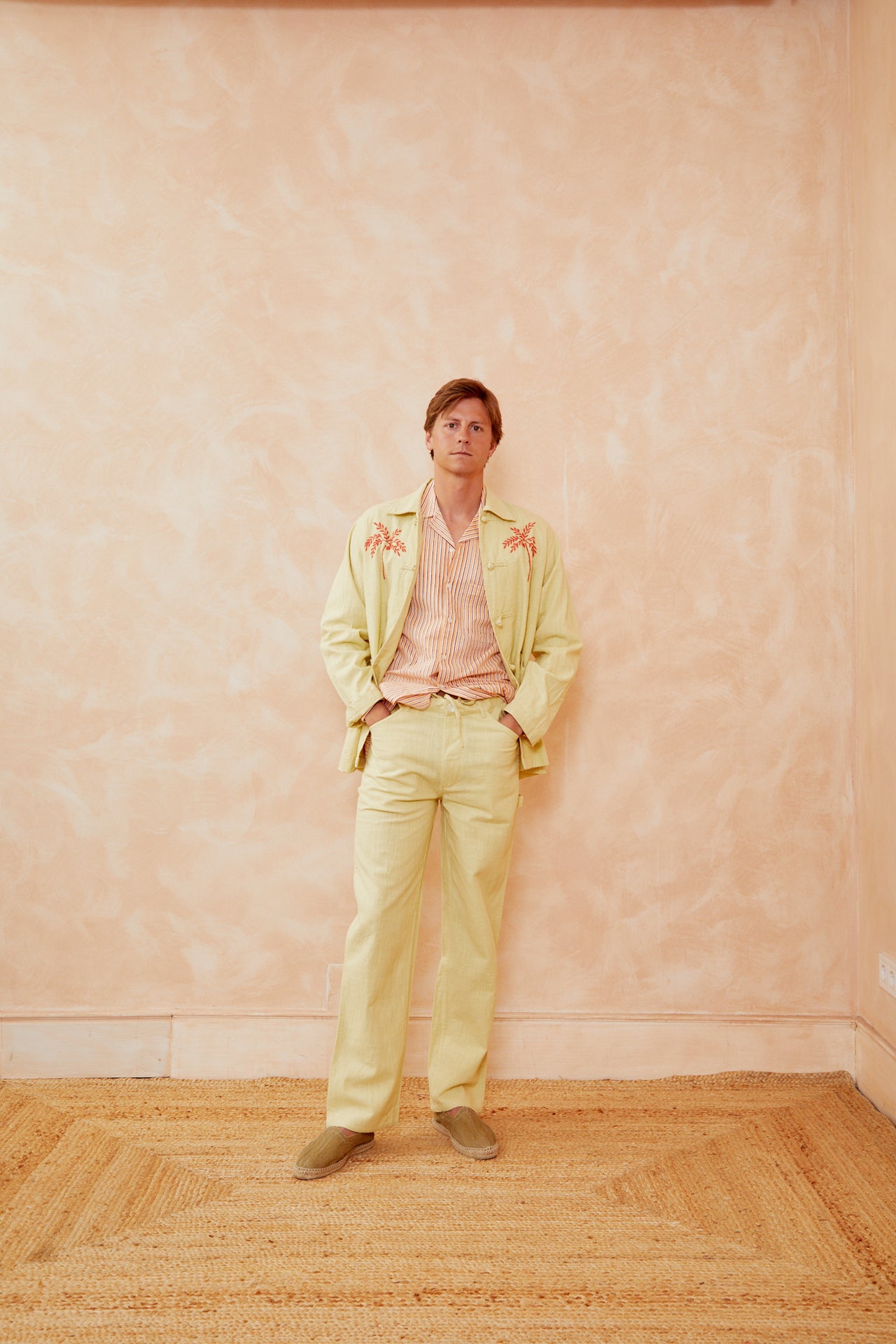 Light green embroidered jacket worn open with a relaxed fit and partial sleeve cuff detail.