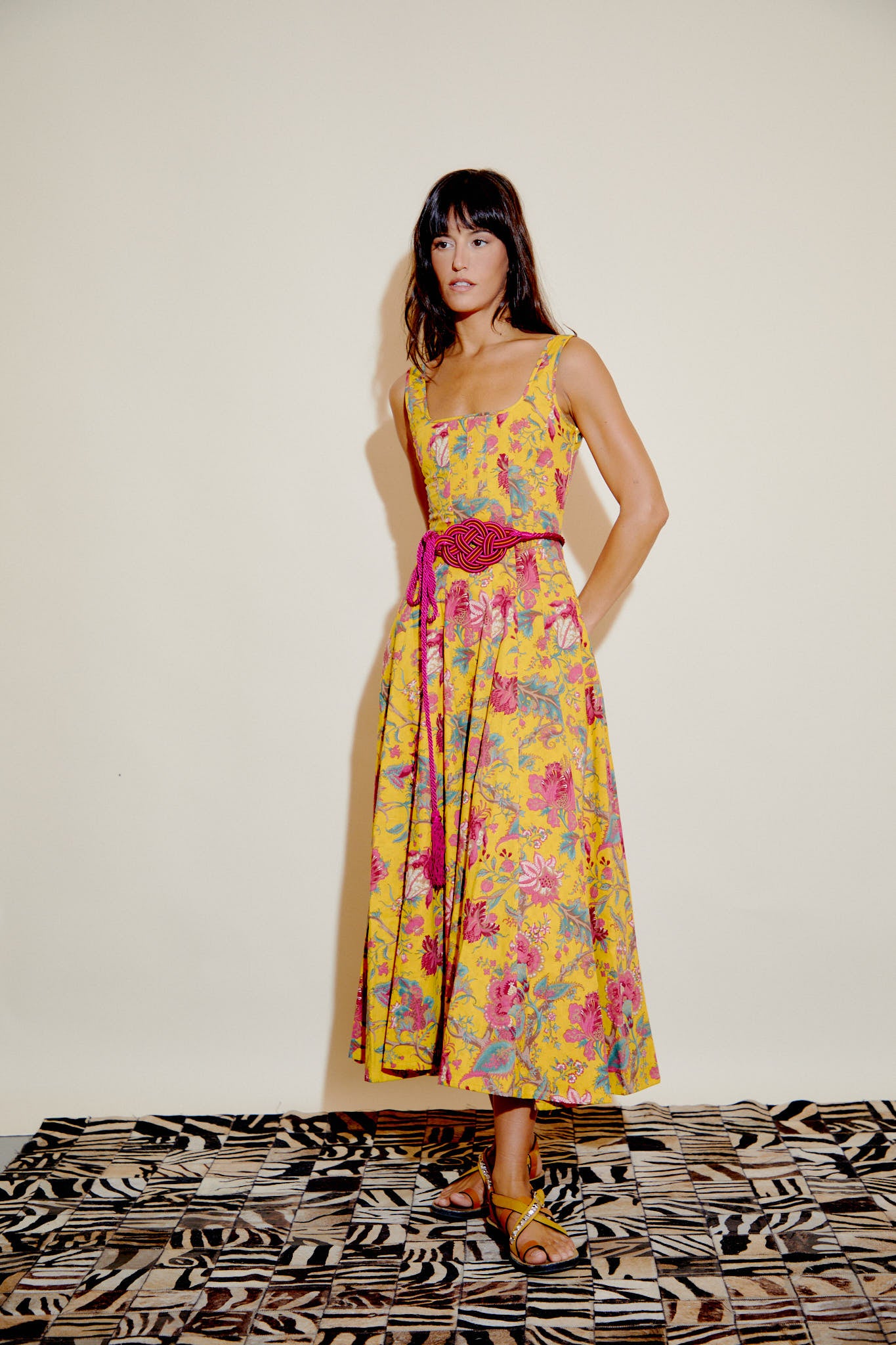 Yellow floral sleeveless dress with fuchsia braided belt and flared midi skirt