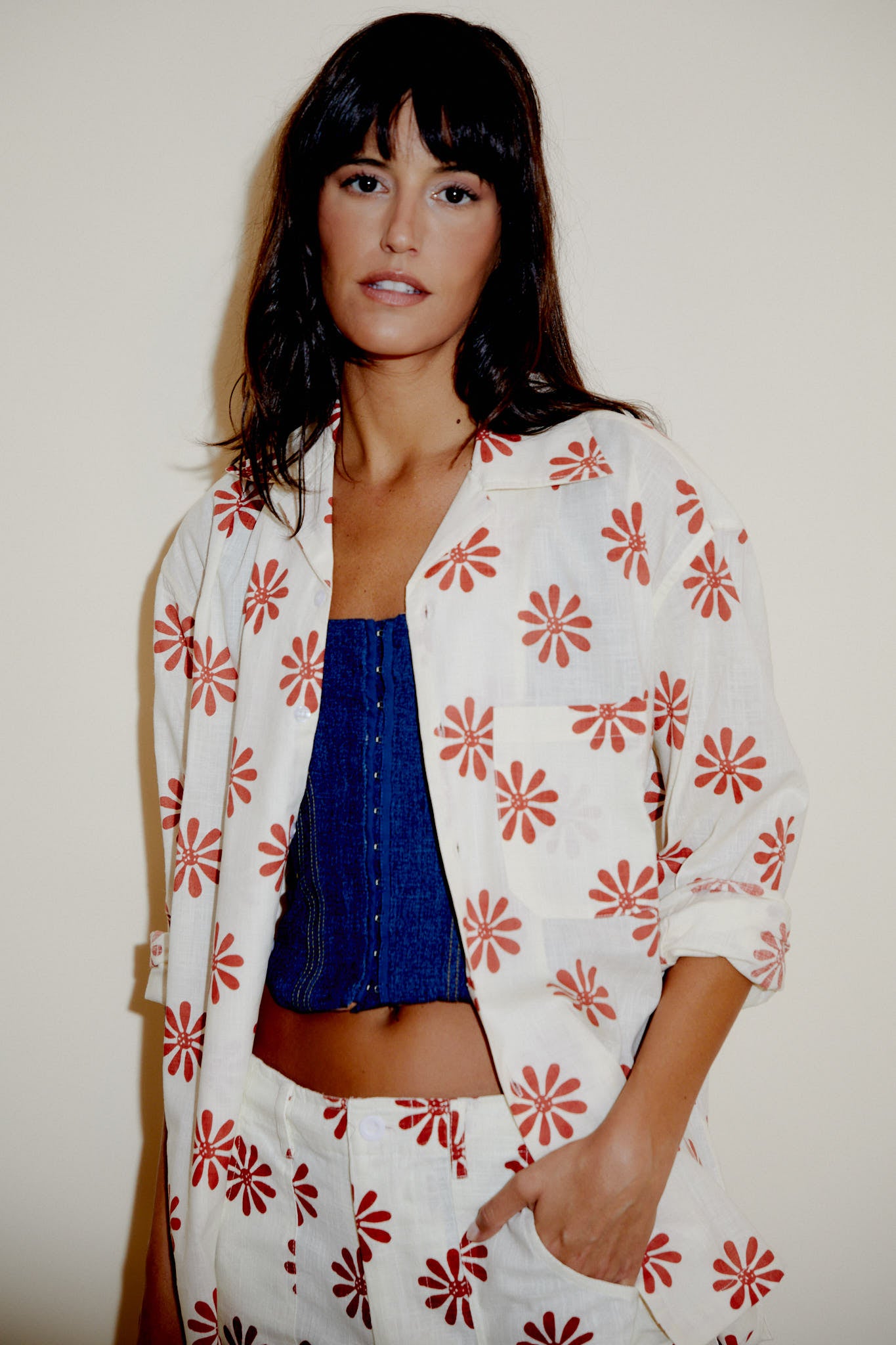 Cream button-up shirt with red flower print, front patch pocket and wide sleeves