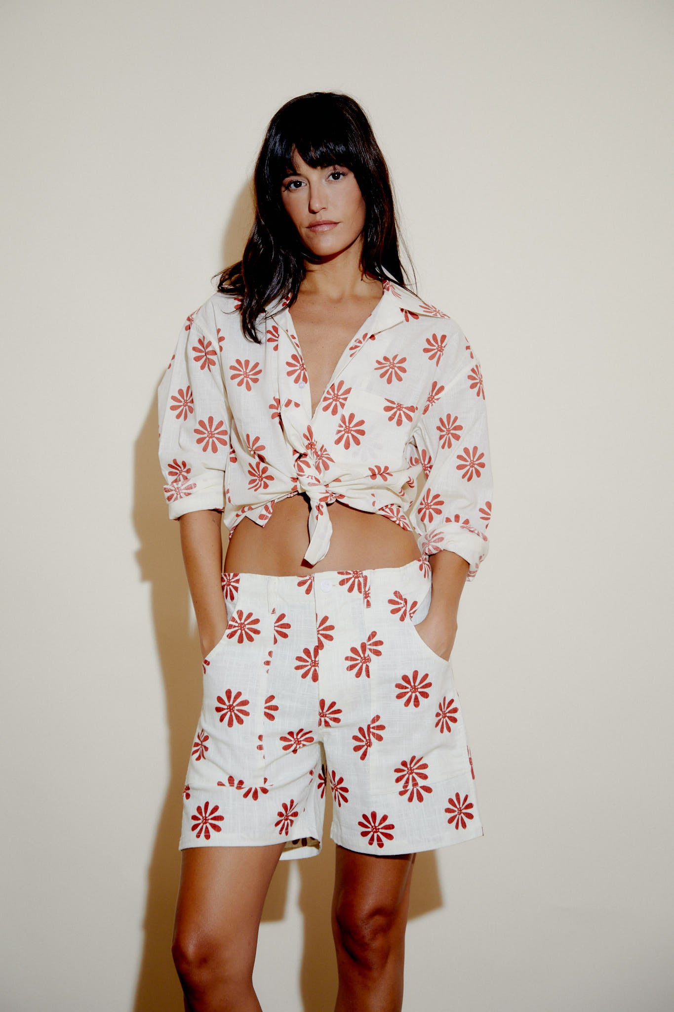 Cream button-up shirt with red flower print, V-neck placket and cuffed sleeves