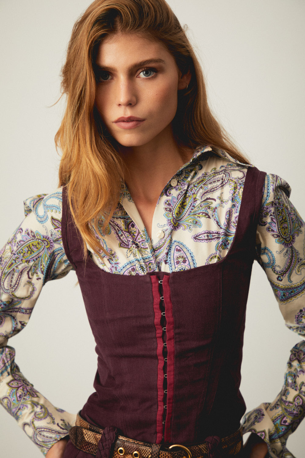 Dark aubergine corset with square neckline, red button-front paneling, and wide waist belt