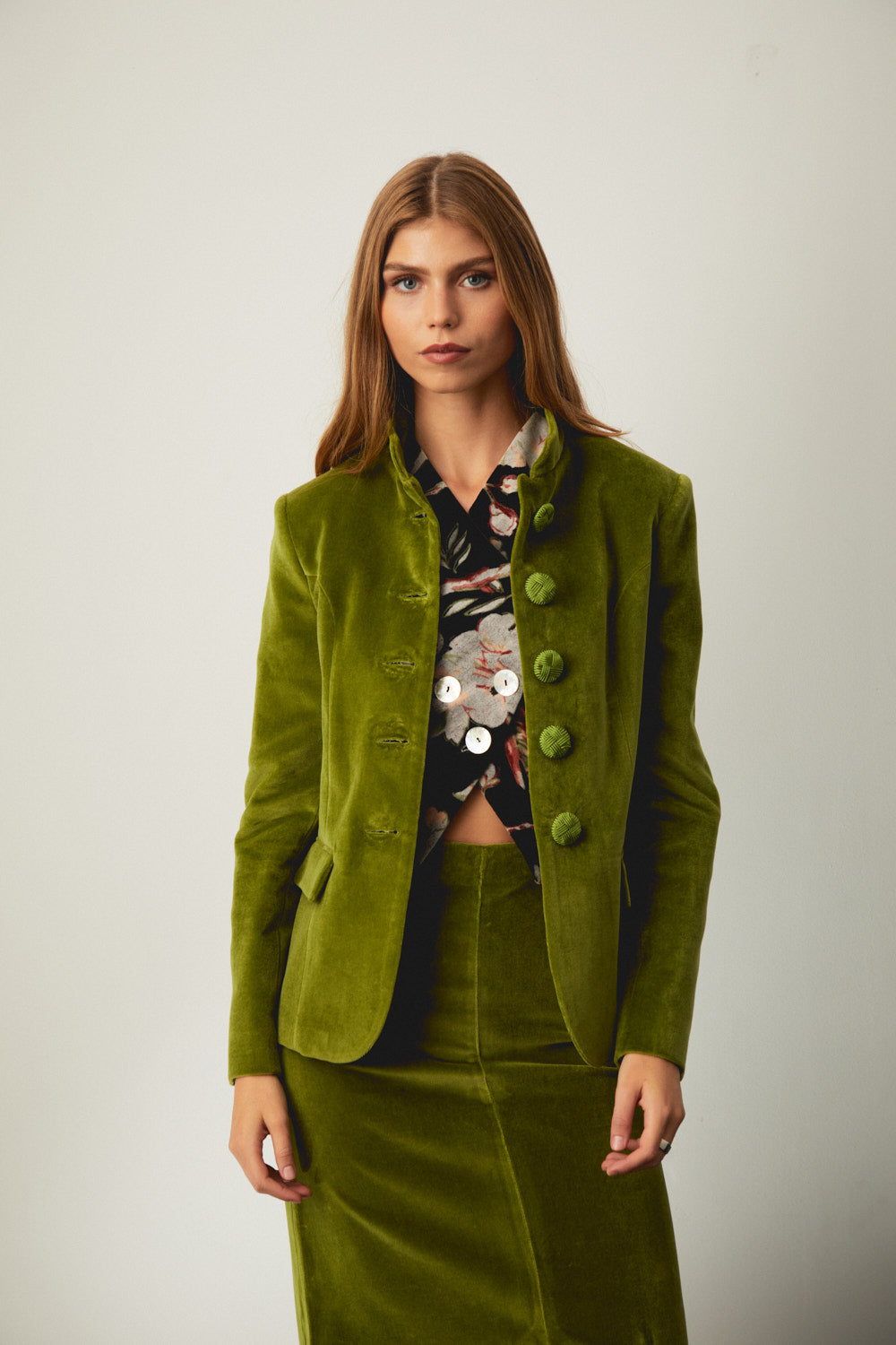 Green suede-style jacket with round buttons, flap pockets, and notched lapels