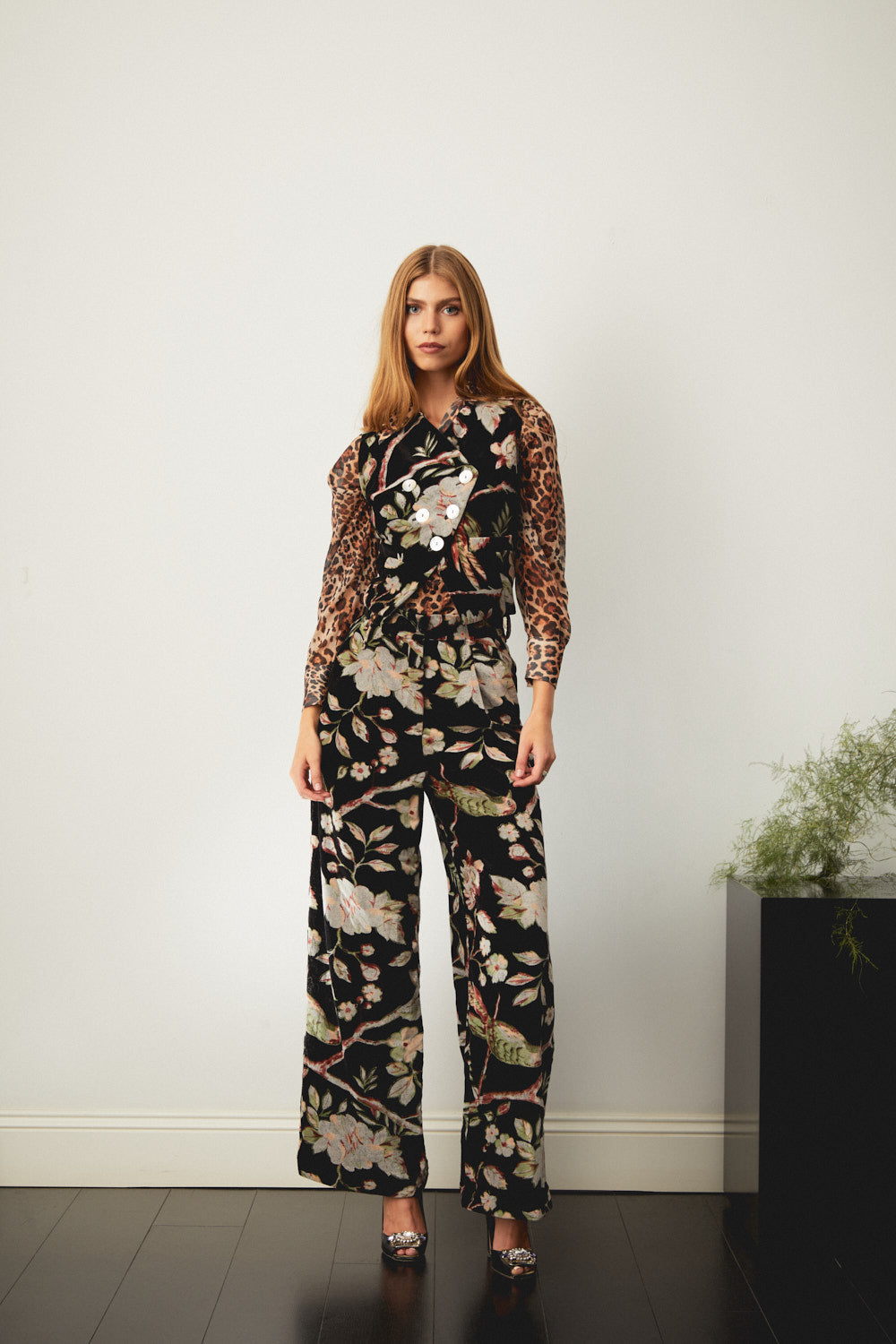 Hilda trousers with a black base and large floral print, shown full length