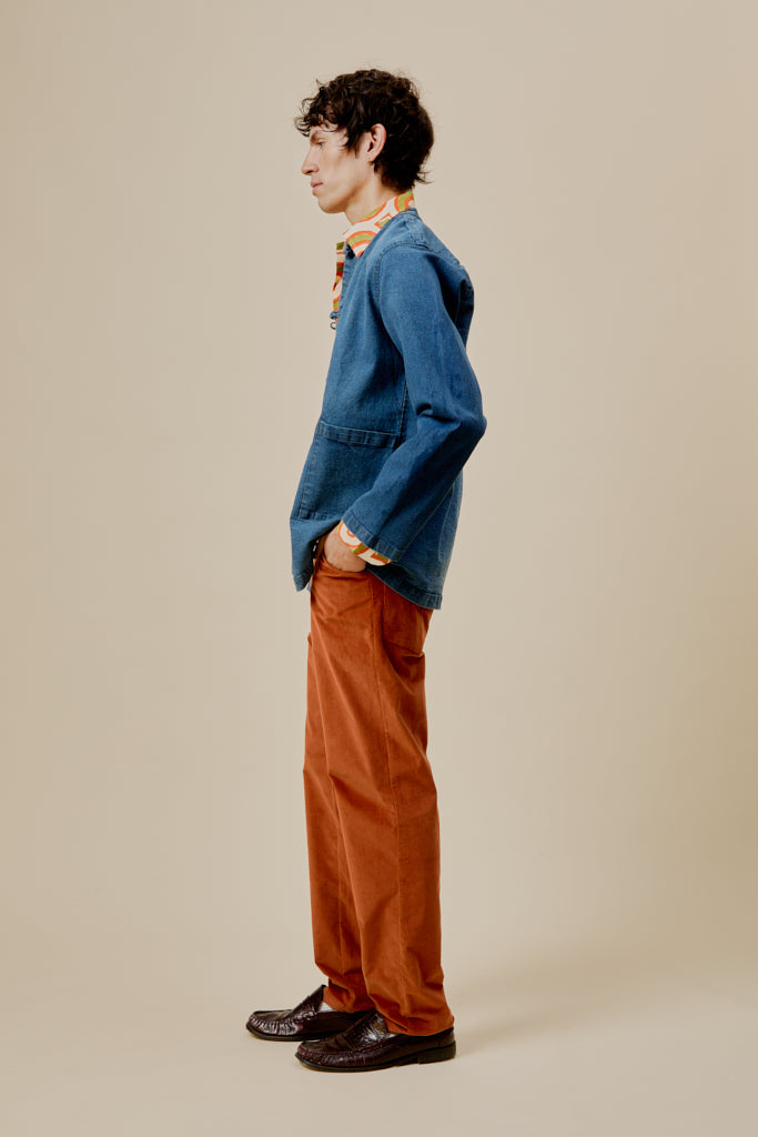 Orange trousers in profile, straight leg with front button closure and pockets