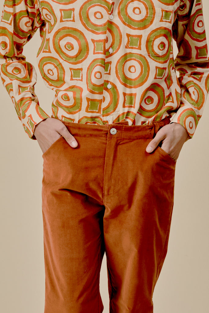 Orange trousers with front button closure, belt loops, and roomy pockets