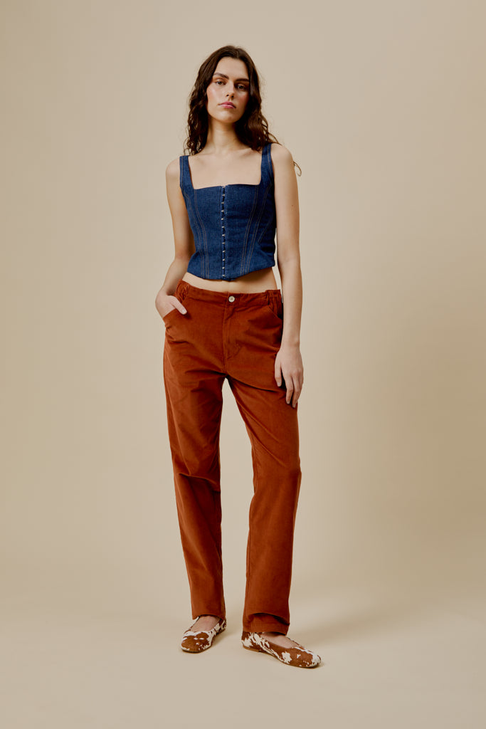 Orange trousers with button fly, belt loops, and relaxed straight silhouette