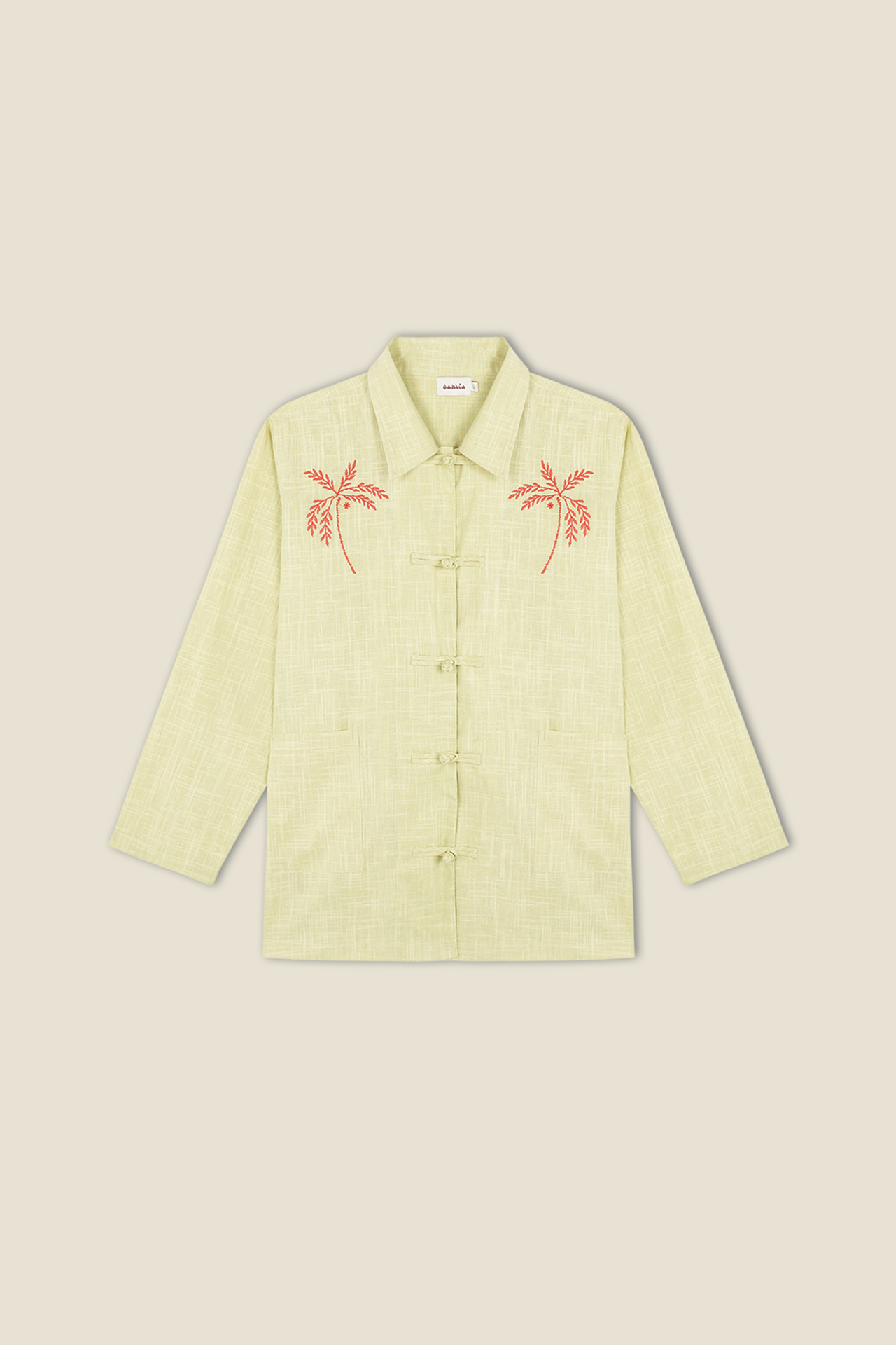 Light green button-up jacket with red embroidered palm tree details on chest pockets.