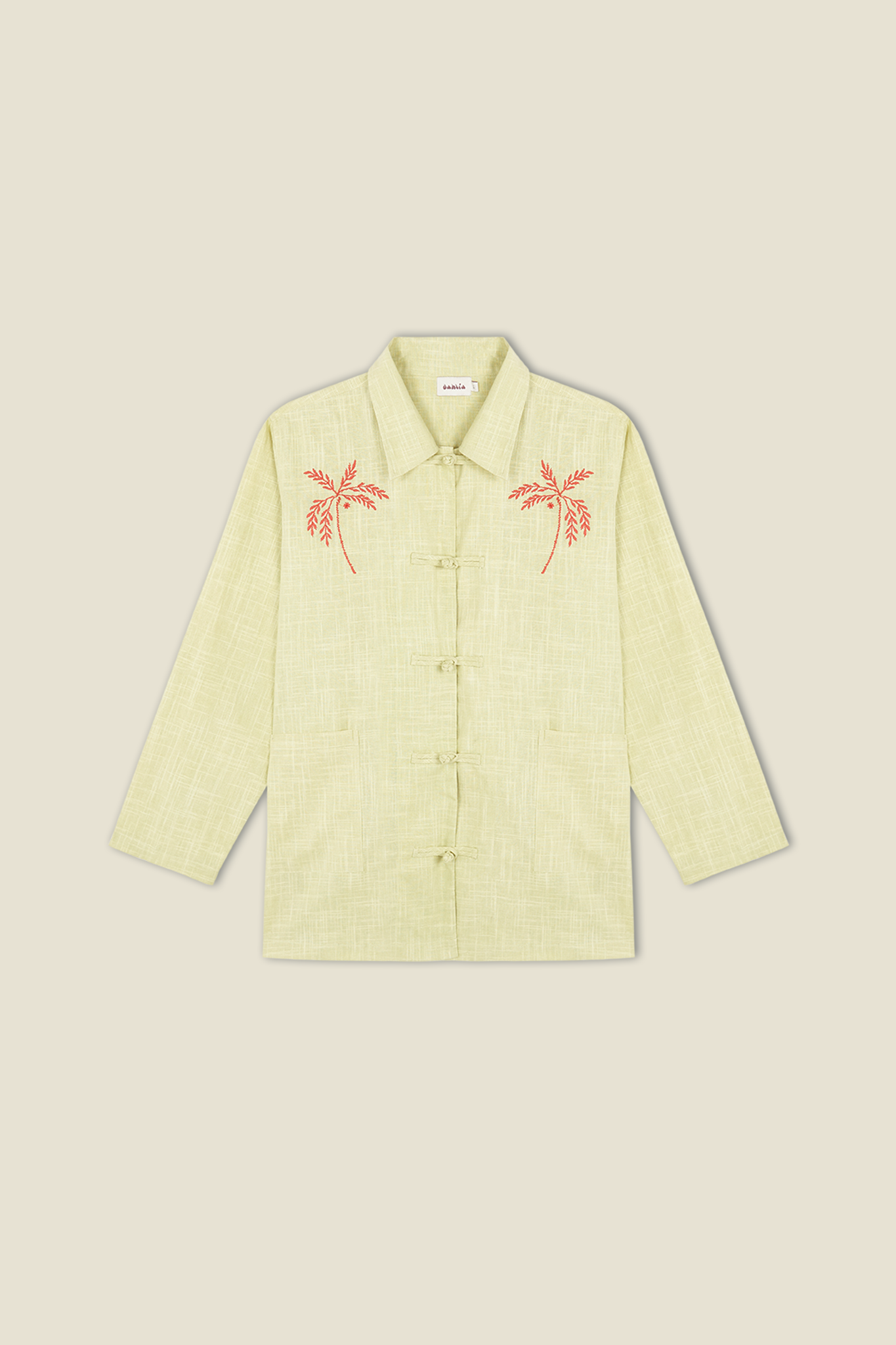 Light green button-up jacket with red embroidered palm tree details on chest pockets.