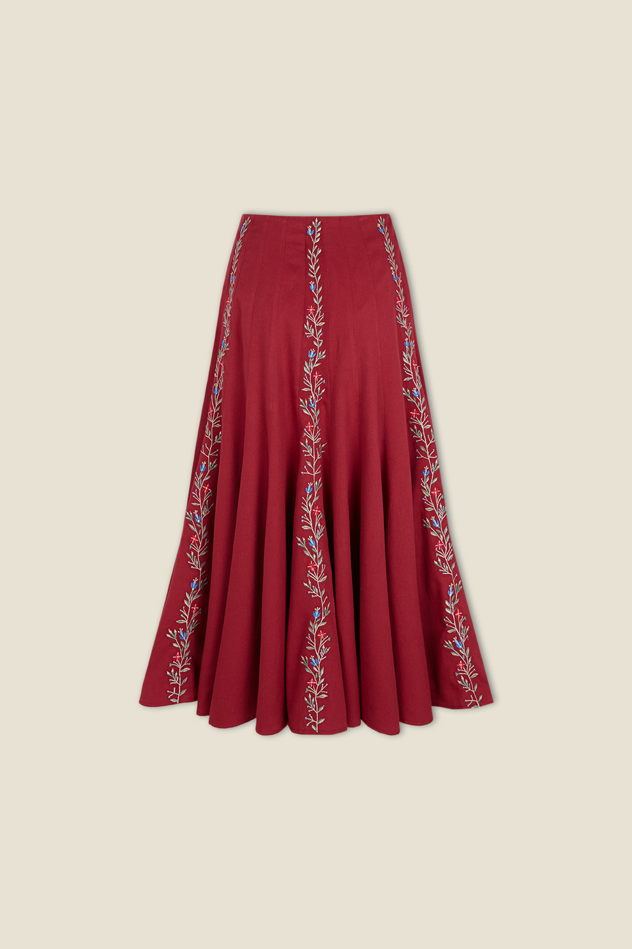 Red pleated skirt with vertical white embroidered vine border at hem