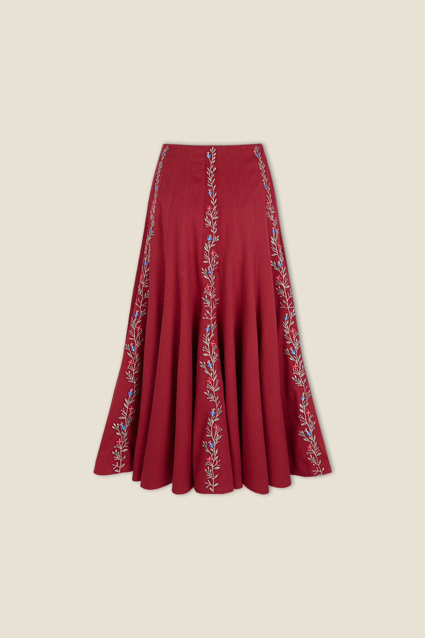 Red pleated skirt with vertical white embroidered vine border at hem