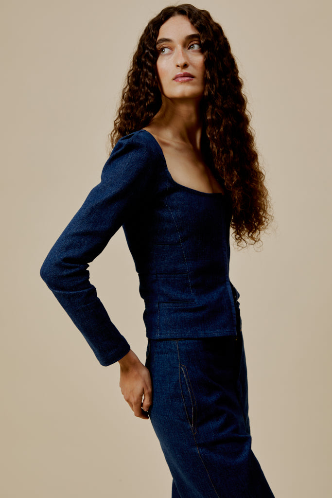 Dark blue denim top with long sleeves, scoop neckline, and fitted waist-length silhouette