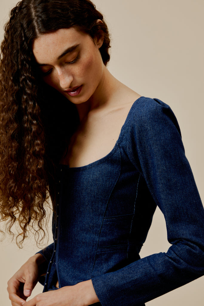 Dark blue denim top with square scoop neckline, long sleeves, and centered button placket