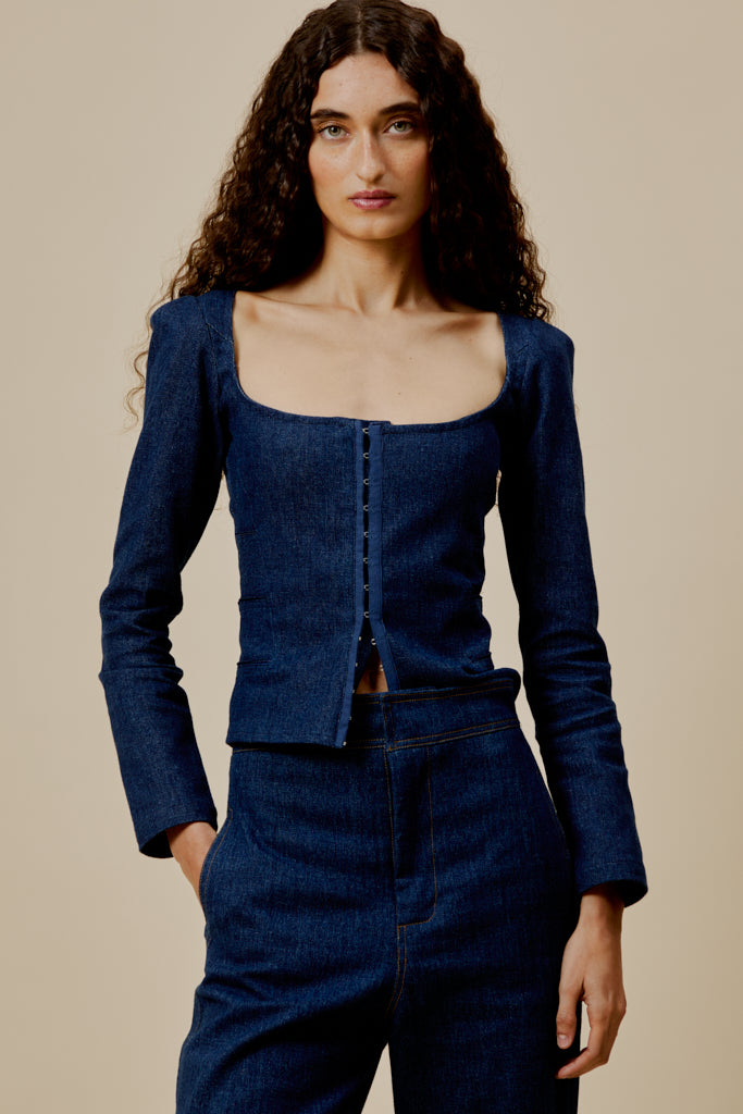 Dark blue denim top with scoop neckline, long sleeves, and centered button front