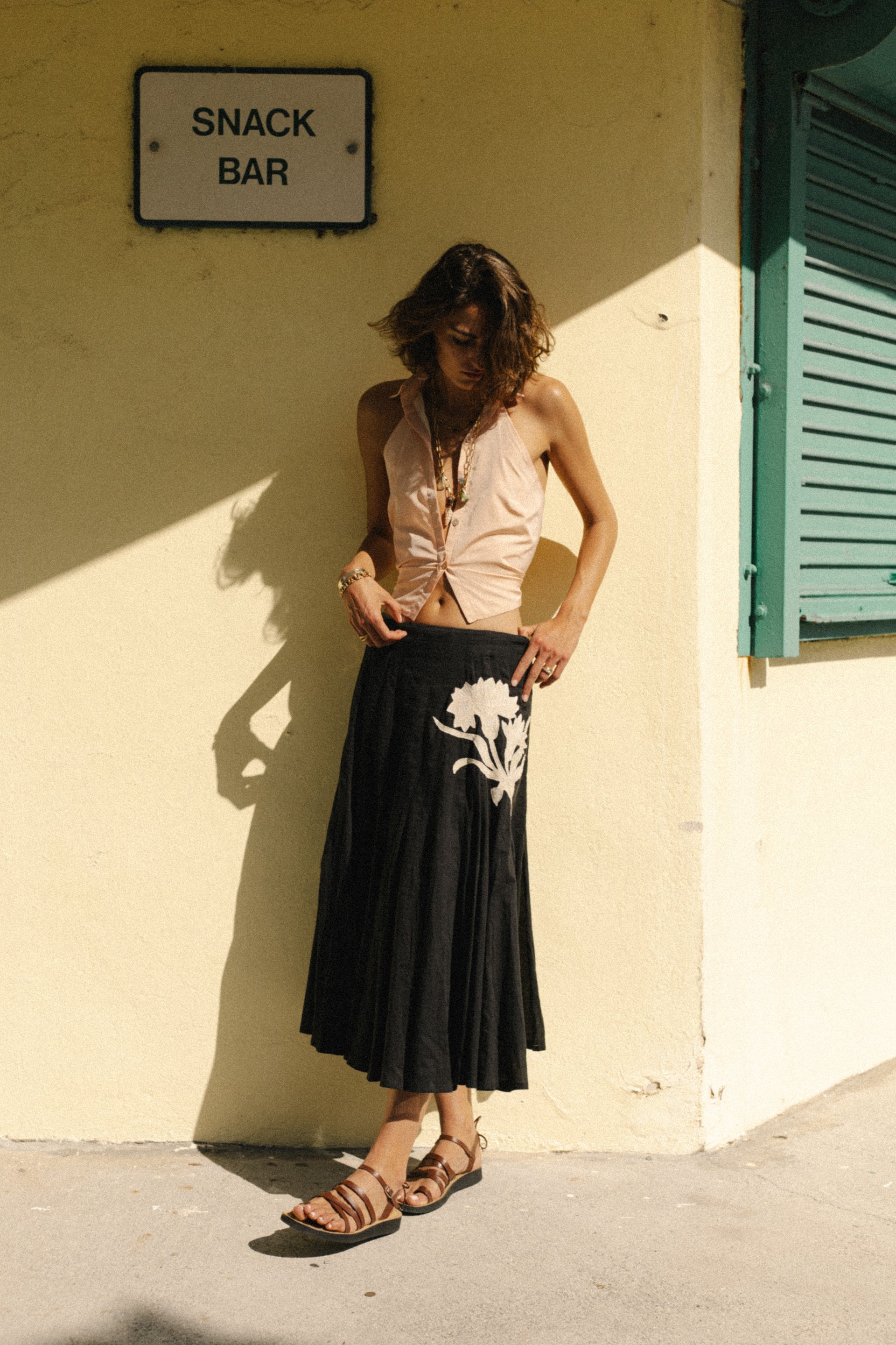 Black pleated midi skirt with prominent white leaf applique panel